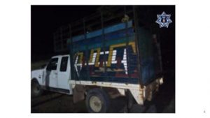 Camioneta Ford F150 cabina y media tipo ganadera color blanco y redilas de varios colores.